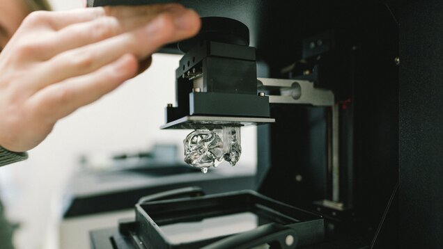 Hand an einer schwarzen Maschine in einem Labor